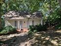 Quaint yellow cottage nestled amongst lush greenery at 322 Mccauley St, Chapel Hill, NC 27516