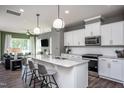 Open concept kitchen features granite island, stainless steel appliances, and white cabinetry at 371 Fosterton Cottage Way, Raleigh, NC 27603