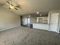 Spacious living room with high ceilings, ceiling fan, and neutral carpeting at 57 Shiloh Dr, Lillington, NC 27546