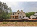An exterior view of a two-story home with a white facade and black trim, set in a partially cleared lot at 1116 Delilia Ln, Wake Forest, NC 27587