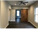 Spacious living room featuring dark floors and a rustic barn door detail at 1312 Fay St, Durham, NC 27701
