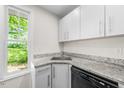 Well-lit kitchen area showcases granite countertops, stainless steel sink, and white cabinets at 2612 Ashe St, Durham, NC 27703