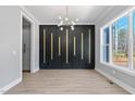 Dining room with modern chandelier, wood accent wall, and lots of natural light at 2662 Sledge Rd, Louisburg, NC 27549