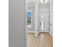 Bright entryway featuring wood-look tile floors, modern light fixture, and white door at 2662 Sledge Rd, Louisburg, NC 27549