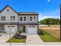 Beautiful two-story townhome with gray siding, white trim, manicured lawn and two-car garage on a sunny day at 712 Jamescroft Way # 26, Rolesville, NC 27571