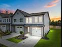 Beautiful two-story townhome with gray siding, white trim, manicured lawn and two-car garage at sunset at 712 Jamescroft Way # 26, Rolesville, NC 27571