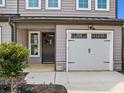 Two-car garage and front entry with dark gray door and stone accents at 712 Jamescroft Way # 26, Rolesville, NC 27571