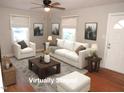 Bright living room featuring hardwood floors, neutral walls, ceiling fan and comfortable seating arrangement at 734 Baker St, Oxford, NC 27565