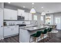 Open kitchen featuring white cabinets, granite island, and pendant lighting at 432 Providence Springs Ln, Fuquay Varina, NC 27526
