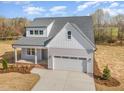 New construction home featuring gray siding, white trim, a two-car garage, and a manicured front lawn at 57 Nottoway Ln, Wendell, NC 27591