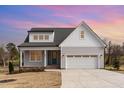 Charming two-story home with gray siding, white trim, a two-car garage, and a manicured front lawn at 57 Nottoway Ln, Wendell, NC 27591
