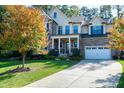 Two story home with stone and shingle exterior, metal roof and landscaping at 5904 Bellona Ln, Raleigh, NC 27612