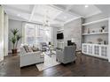 Bright and airy living room featuring a coffered ceiling, fireplace, built-in shelves, and large windows with natural light at 5904 Bellona Ln, Raleigh, NC 27612
