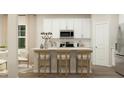 Modern kitchen with white cabinets, island, and stainless steel appliances at 605 Morning Light Dr, Angier, NC 27501