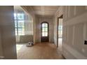 Entryway showing arched, dark-stained front door and unfinished walls, indicative of new construction at 7934 Wexford Waters Ln, Wake Forest, NC 27587