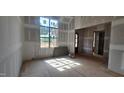 Spacious living room with large window and rough walls during the construction process at 7934 Wexford Waters Ln, Wake Forest, NC 27587