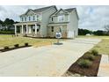 Long concrete driveway leading to a well-maintained two-story home with an attached garage at 90 Demascus Way # 024, Four Oaks, NC 27524