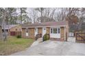 Brick ranch house with a front yard, driveway, and wooden fence at 915 Da Vinci St, Durham, NC 27704