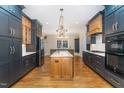 Spacious kitchen with dark cabinetry, granite island, and stainless steel appliances at 113 Meadowglades Ln, Cary, NC 27518