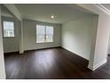 A light filled room with dark wood floors, white walls, trim, and natural light at 1528 Goldfinch Perch Ln, Knightdale, NC 27545
