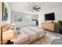 Virtually staged main bedroom with light wood furniture and a large TV at 3113 Skybrook Ln, Durham, NC 27703