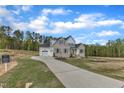 Stunning view of home, with three-car garage, manicured lawn, and a long winding driveway at 3803 Bennett Grove Dr, Wake Forest, NC 27587
