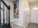 Bright entryway with staircase, art, and neutral color palette at 431 Oak Run Dr, Raleigh, NC 27606