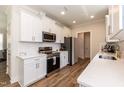 Modern kitchen with white cabinets, quartz countertops, and stainless steel appliances at 438 S Hillsborough St, Franklinton, NC 27525