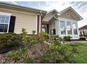 Exterior of home with a brick and tan color scheme and a sunroom addition at 4712 Fox Fern Ln, Raleigh, NC 27604