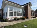 Sunroom with large windows, brick exterior, and beautiful landscaping at 4712 Fox Fern Ln, Raleigh, NC 27604