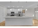 Bright kitchen features white cabinets, stainless steel appliances, and a large center island with stone countertop at 1119 Sagamore Dr, Louisburg, NC 27549