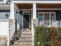 Inviting front porch with stone pillars and a charming front door at 114 Naperville Dr, Cary, NC 27519
