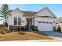 White house with gray stone accents, two-car garage, and landscaping at 1177 St. Cloud Loop, Apex, NC 27523