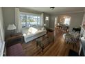 Inviting living room featuring hardwood floors, large windows, and an open layout to the dining area at 1302 E Jones St, Raleigh, NC 27610