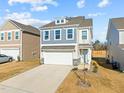 Two-story home with a two-car garage, blue and white siding, dormer window, and well-manicured lawn at 168 Begonia St, Angier, NC 27501