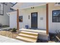 Quaint front porch with a dark gray door and wooden posts at 2207 Edwin Ave, Durham, NC 27705