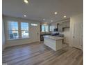 Well-lit kitchen showcases stainless steel appliances, a granite island, and a view from three large windows at 6336 Granite Quarry Dr, Raleigh, NC 27610