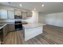 Bright kitchen featuring an island with granite countertops, stainless steel appliances, and ample cabinet space at 6336 Granite Quarry Dr, Raleigh, NC 27610