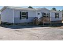Gray single wide manufactured home with a wooden deck and spacious yard at 6545 Old Jefferson Davis Hwy, Cameron, NC 28326