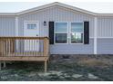 Front view of manufactured home with gray siding, white door and black shutters at 6545 Old Jefferson Davis Hwy, Cameron, NC 28326