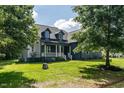 Charming two-story home with a welcoming front porch, green lawn and mature trees at 20 Tamaran Ct, Spring Hope, NC 27882