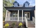 Inviting front porch with decorative railing, brick accents, and a welcoming entrance with white trimmed doors at 20 Tamaran Ct, Spring Hope, NC 27882