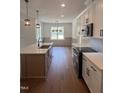 Modern kitchen featuring a large island, stainless steel appliances, white cabinets, and stylish pendant lighting at 20 Tamaran Ct, Spring Hope, NC 27882