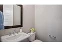 Elegant powder room featuring a pedestal sink, dark wood framed mirror and neutral decor at 224 Wash Hollow Dr, Wendell, NC 27591