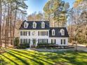 Two-story white house with green shutters, a manicured lawn, and mature trees at 3 Acornridge Ct, Durham, NC 27707
