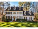 Two-story white house with green shutters, a manicured lawn, and mature trees at 3 Acornridge Ct, Durham, NC 27707