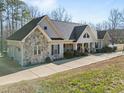 Charming ranch style home features stone accents, inviting front porch, and an attached two car garage at 413 Johnson Town Rd, Zebulon, NC 27597