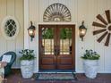 Elegant double front door with decorative accents, sconces, and potted plants for a warm welcome at 413 Johnson Town Rd, Zebulon, NC 27597