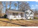 Gray sided ranch home with white brick skirt, covered porch and mature trees at 420 W 10Th St, Siler City, NC 27344