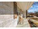 Relaxing front porch with wooden bench and white brick exterior at 420 W 10Th St, Siler City, NC 27344